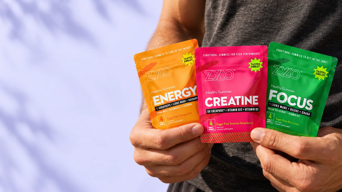 Hands holding ZYLO Energy, Creatine and Focus single-serving pouches